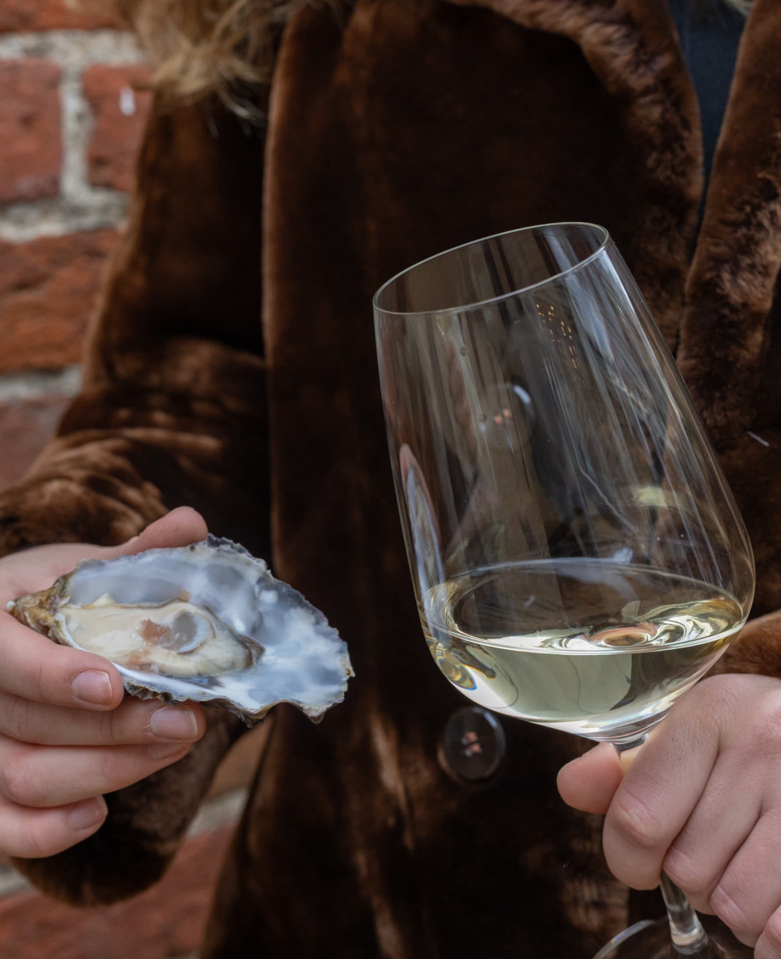 Gast met een oester en een glas witte wijn